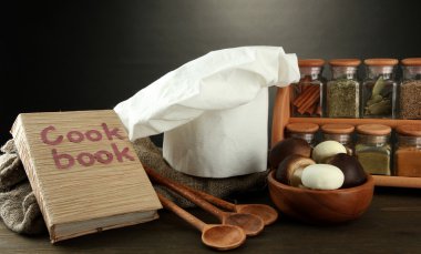 Şef'in şapkası ve kitchenwear tabloda gri arka plan üzerinde kompozisyonu