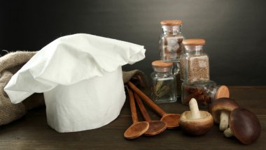 Şef'in şapkası ve kitchenwear tabloda gri arka plan üzerinde kompozisyonu