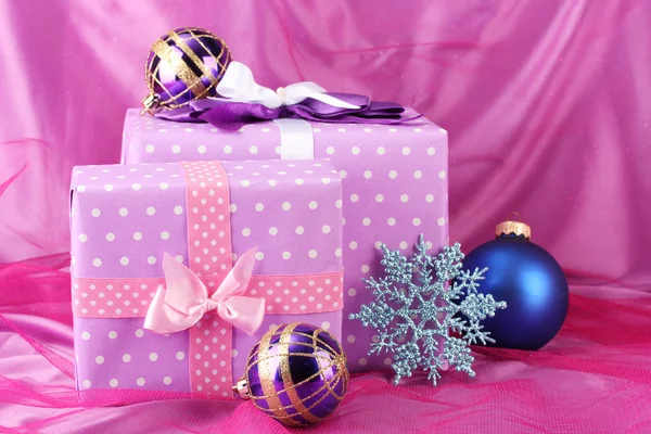 Hermosos regalos, bolas de Navidad y copo de nieve sobre un fondo rosa — Foto de Stock