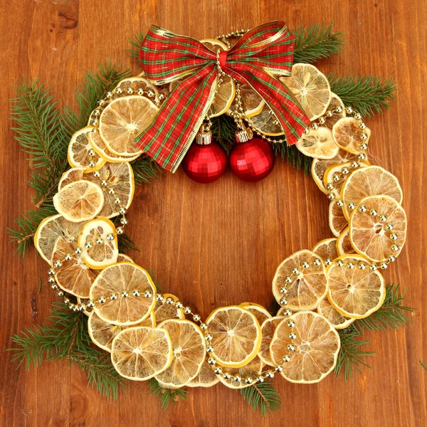 Corona de Navidad de limones secos con abeto y bolas, sobre fondo de madera —  Fotos de Stock