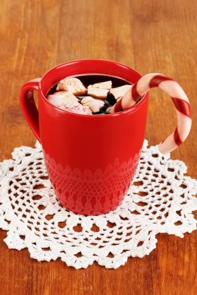 Cup of coffee with holiday candy on wooden table close-up — Stock Photo, Image