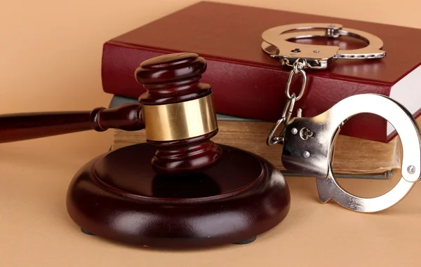 Gavel, handcuffs and book on law on beige background — Stock Photo, Image