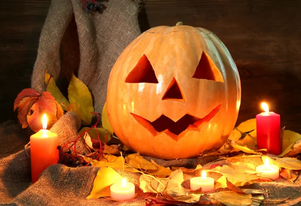 Zucca di Halloween e foglie autunnali, su sfondo di legno — Foto Stock