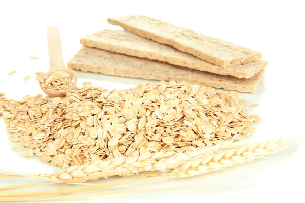 Flocos de aveia em colher de madeira com espiguetas e biscoitos de aveia isolados em branco — Fotografia de Stock