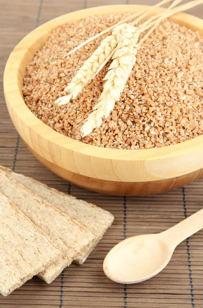 Wooden bowl full of wheat bran — Stock Photo, Image