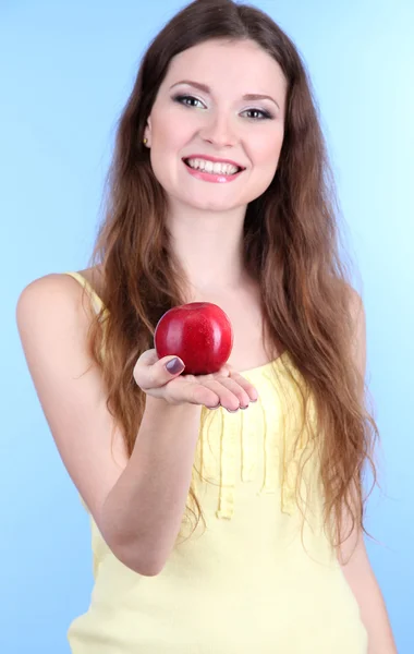 Όμορφη γυναίκα με το μήλο σε μπλε φόντο — Φωτογραφία Αρχείου