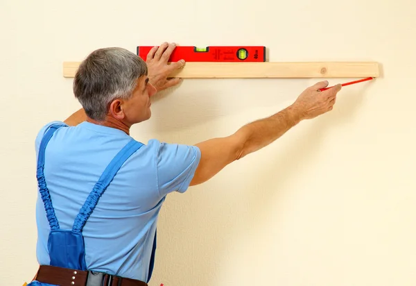Будівельник вимірює стіну в кімнаті крупним планом — стокове фото