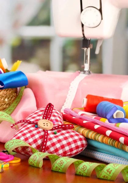 Sewing machine and fabric on bright background — Stock Photo, Image