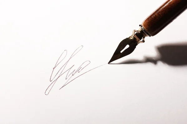 Close-up van handtekening (nep, niet echt) en inkt pen, geïsoleerd op wit — Stockfoto