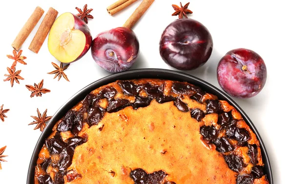 Torta saborosa na panela com ameixas e canela isolada em branco — Fotografia de Stock