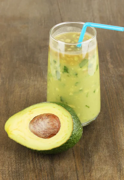 Useful fresh avocado and half avocado on wooden table close-up — Stock Photo, Image