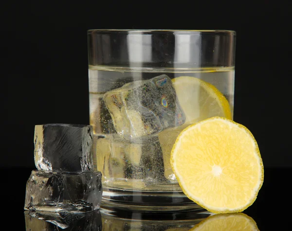 Cubos de hielo en vidrio con limón aislado en negro —  Fotos de Stock