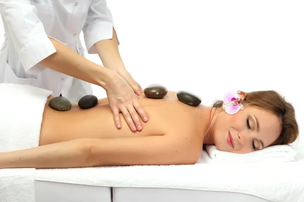 Beautiful woman in spa salon with spa stones getting massage, isolated on white — Stock Photo, Image