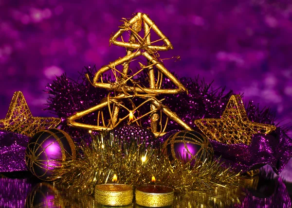 Composizione natalizia con candele e decorazioni nei colori viola e oro su sfondo luminoso — Foto Stock