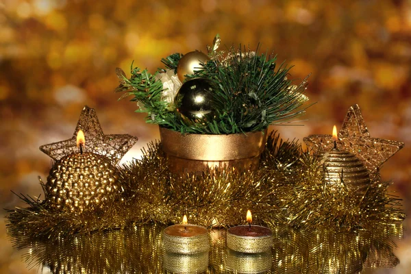 Рождественская композиция со свечами и украшениями в золотом цвете на ярком фоне — стоковое фото