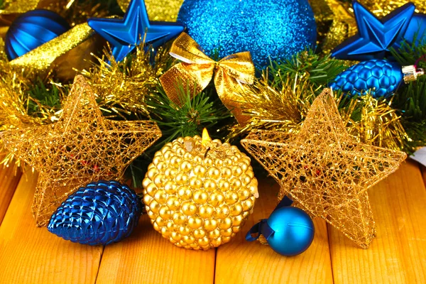 Kerstmis samenstelling met kaarsen en decoraties in blauwe en gouden kleuren op houten achtergrond — Stockfoto