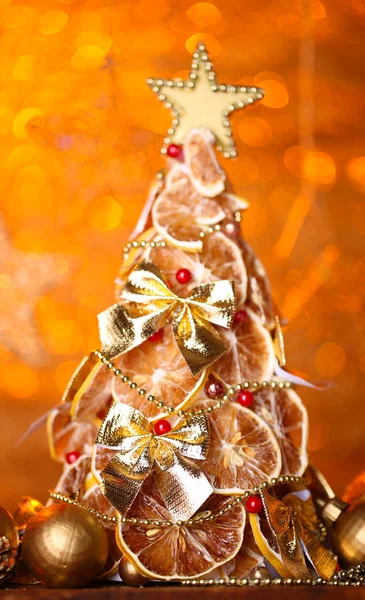 Prachtige Kerstboom van droge citroenen met decor, op oranje achtergrond — Stockfoto