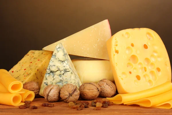 Різні види сиру на дерев'яному столі на коричневому фоні — стокове фото