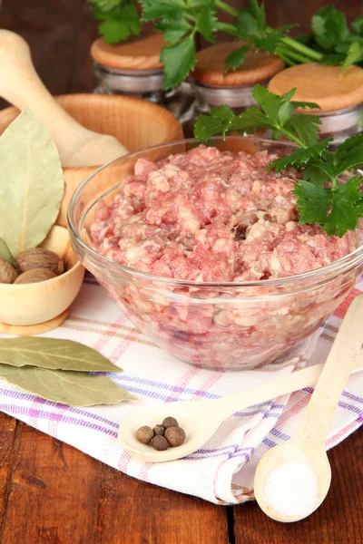 Bowl of raw ground meat with spices on wooden table Royalty Free Stock Photos
