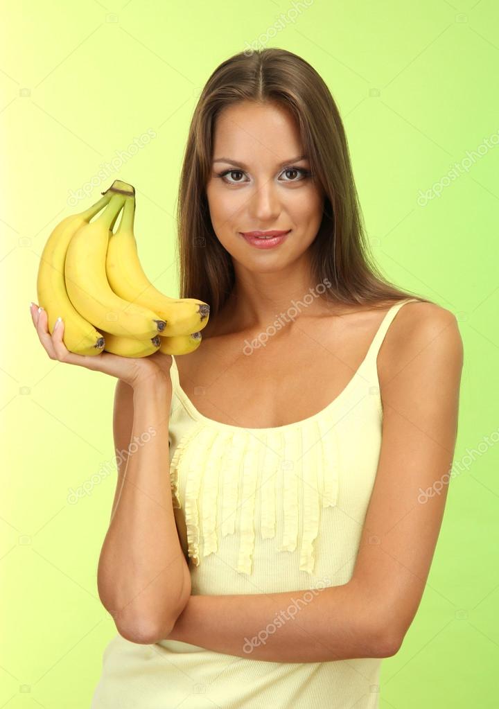 Beautiful young woman with bananas, on green background — Stock Photo