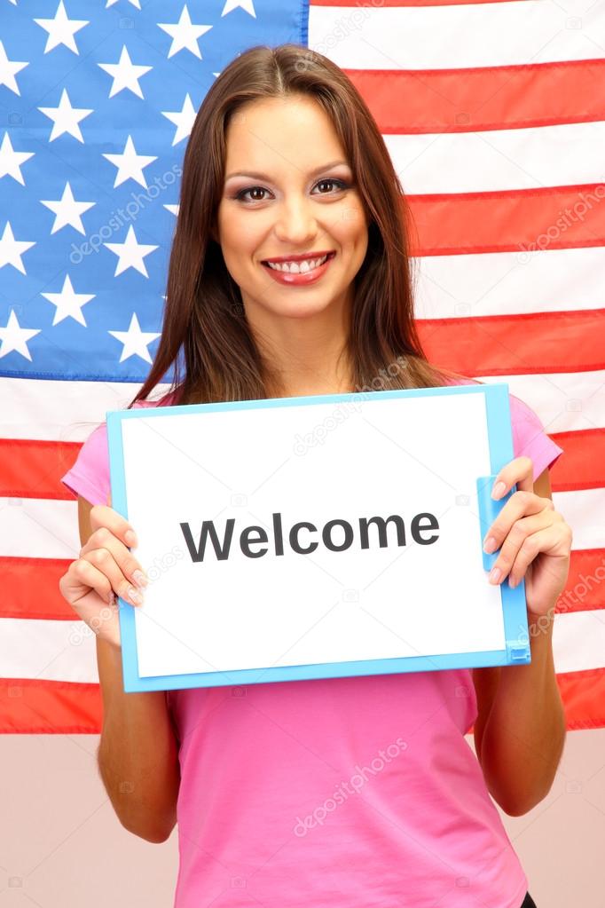 Young woman young woman holding tablet on background of American flag