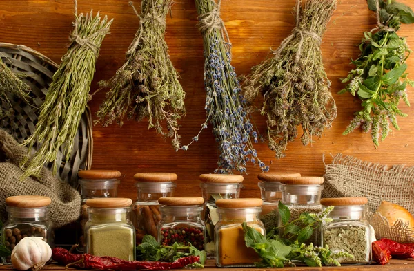 Ervas secas, especiarias e pimenta, sobre fundo de madeira — Fotografia de Stock