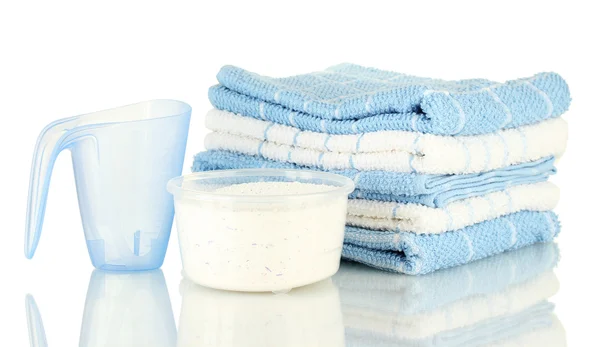 Измерительные чашки со стиральным порошком и полотенцами, изолированные на белом — стоковое фото