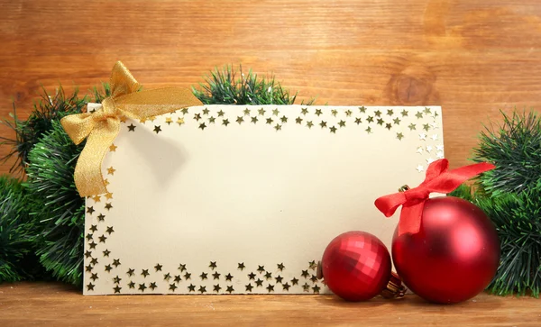 Hermosa composición de Navidad con postal vacía sobre fondo de madera — Foto de Stock