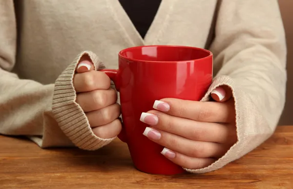 Hände halten Becher mit Heißgetränk, Nahaufnahme — Stockfoto