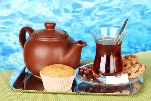 Glass of Turkish tea and kettle on color background — Stock Photo, Image