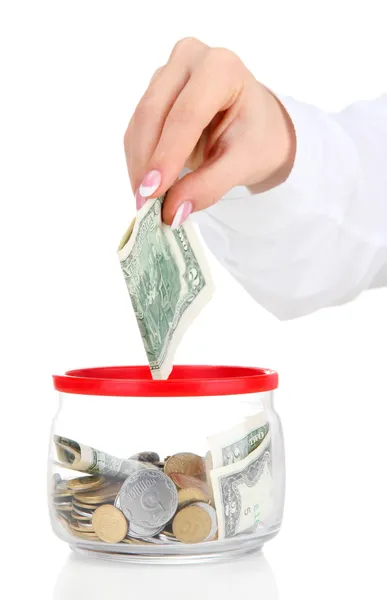 Woman hand with money in glass jar isolated on white — Stock Photo, Image