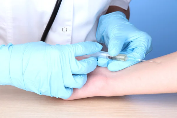 Vaccin injectie in hand op blauwe achtergrond — Stockfoto