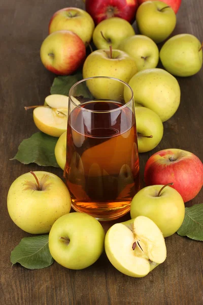 Užitečné Jablečná šťáva s kolem jablek na dřevěný stůl — Stock fotografie