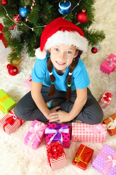 크리스마스 트리 근처에 앉아 어린 소녀 — 스톡 사진