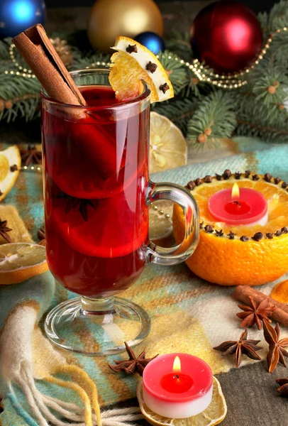 Vino caliente fragante en vaso con especias y naranjas en la mesa de madera —  Fotos de Stock