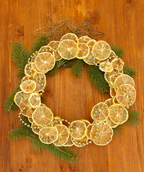 Corona de Navidad de limones secos con abeto y estrellas, sobre fondo de madera — Foto de Stock