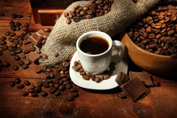 Coffee grinder and cup of coffee on brown wooden background — Stock Photo, Image