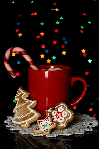 Cup of coffee with holiday candy on Christmas lights background — Stock Photo, Image