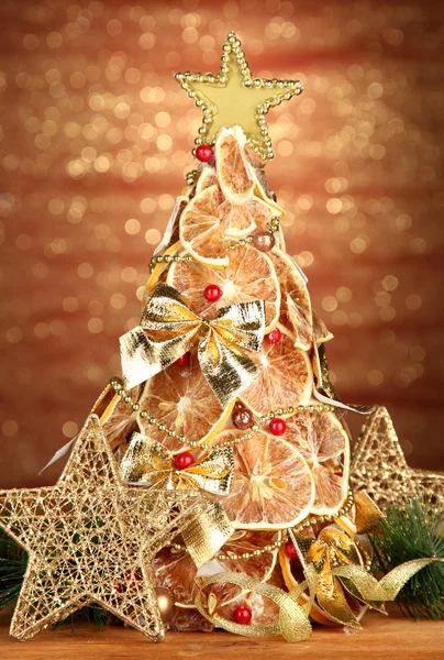 Beau sapin de Noël de citrons secs avec décor, sur fond de brillance — Photo