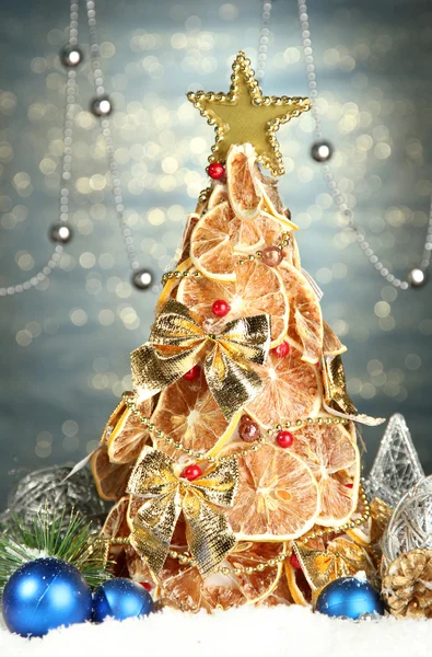 Gyönyörű karácsonyfa száraz citrom berendezéssel, ragyog a kék háttér — Stock Fotó