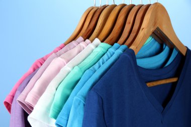 casual gömlekler mavi zemin üzerine ahşap askı üzerinde çeşitli