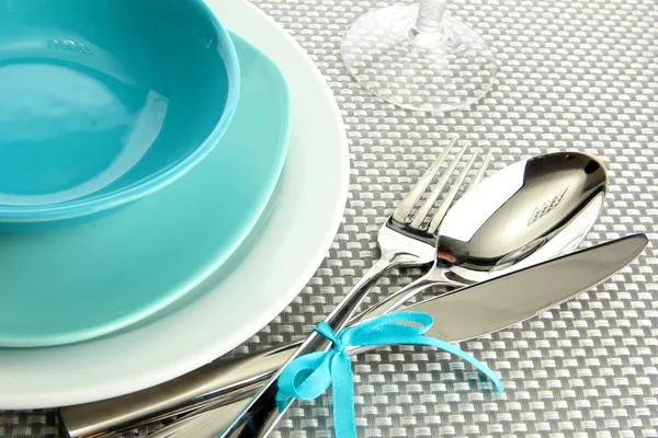Platos vacíos azules con tenedor, cuchara y cuchillo sobre un mantel gris — Foto de Stock