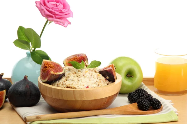 Tasty oatmeal with fruits glass of juice, on wooden table — Stock Photo, Image