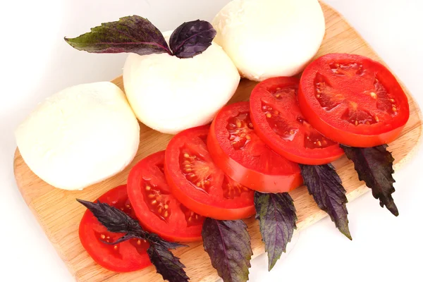 Savoureuse mozzarella aux tomates sur planche à découper isolée sur blanc — Photo