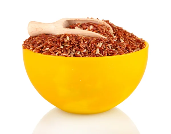 Tahta kepçeli sarı bir tabakta kırmızı pirinç, beyaz üzerine izole edilmiş. — Stok fotoğraf