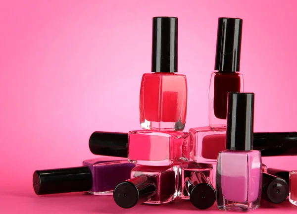 Group of bright nail polishes, on pink background — Stock Photo, Image