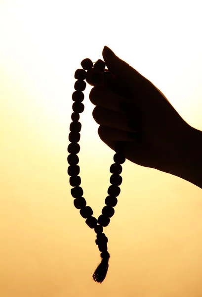 Female hands with rosary, on beige background — Stock Photo, Image