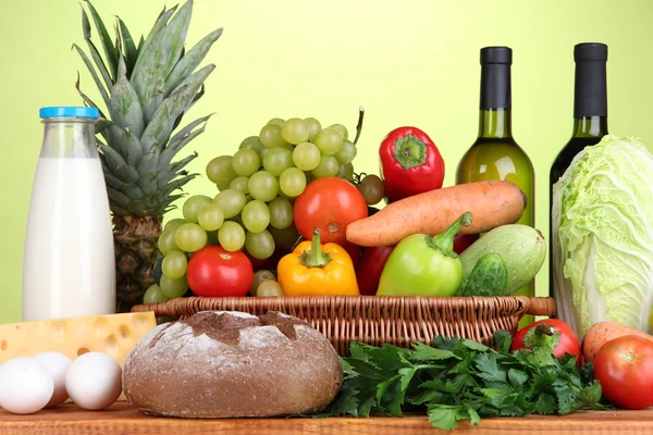 Состав с овощами в плетеной корзине на зеленом фоне — стоковое фото
