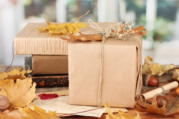 Jesienny skład z darem, książki i pozostawia na jasnym tle — Zdjęcie stockowe