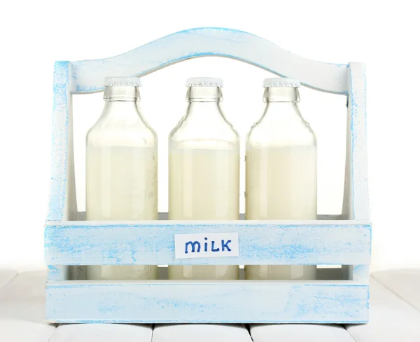 Lapte în sticle în cutie de lemn pe masă de lemn pe fundal alb — Fotografie, imagine de stoc